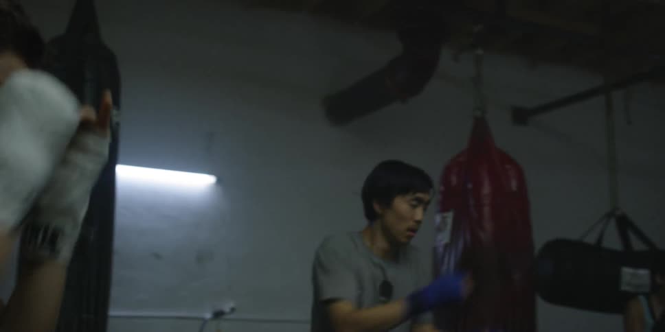 Man and woman practice punching in a gym