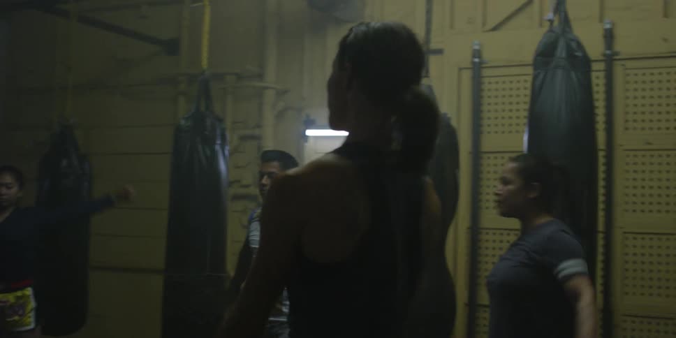 A group of fighters are doing exercises inside a gym