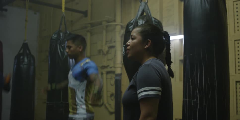Woman instructs several students who are doing jumping jacks