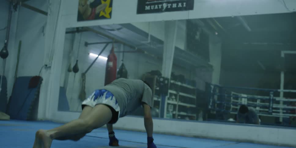 A man stretches and does floor exercises in front of the gym mirror
