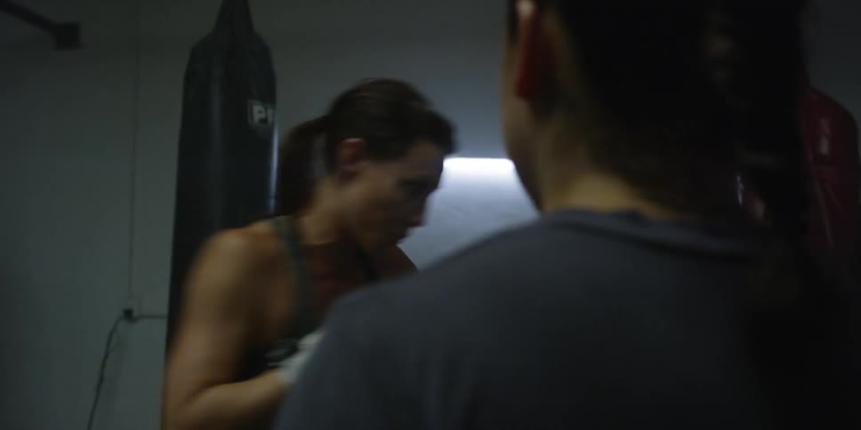 A woman punches the air in a gym