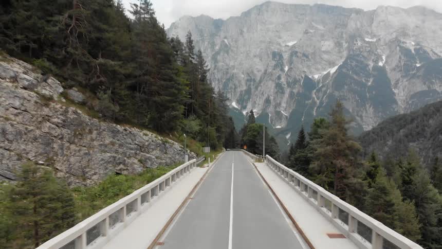 Cars drive on a mountain road