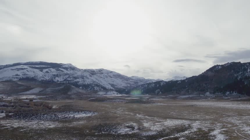 Clouds float above snowy mountains