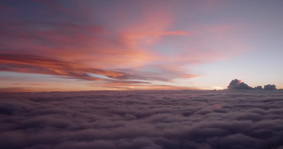 The sun sets over clouds in the sky