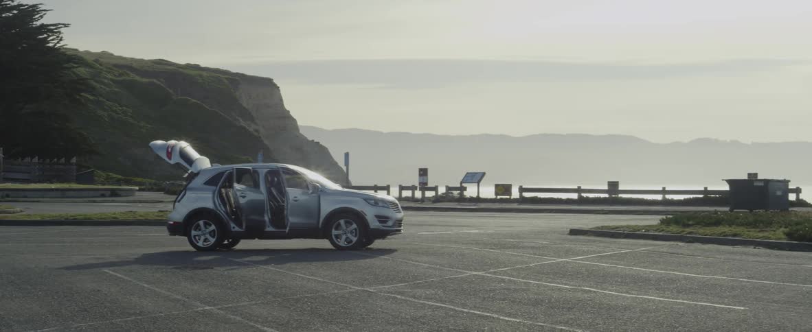 Suv in an empty parking lot with all of its doors open on a hazy day