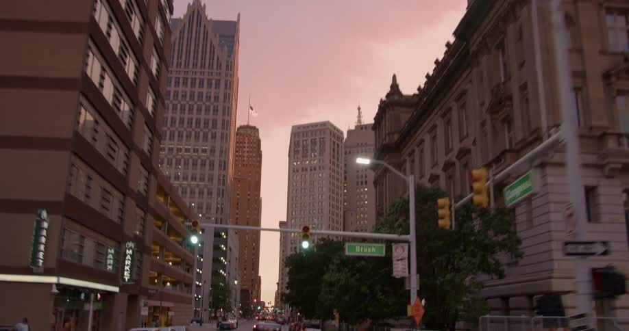 Cars drive on a city street at sunset