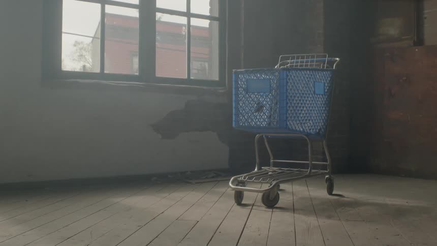 Blue shopping cart in an empty room next to a window
