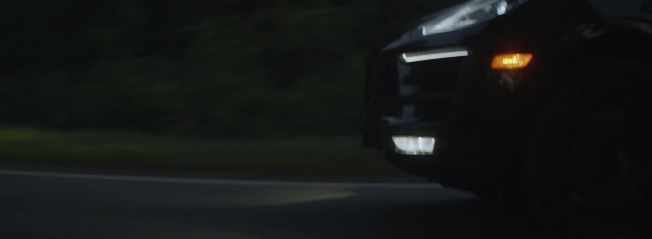 Vehicle drives down a road at night