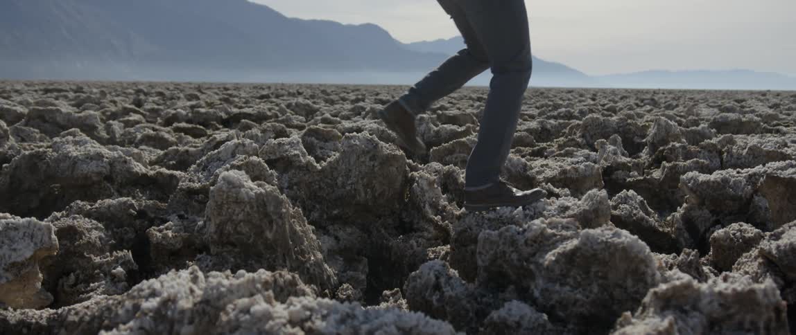 A man steps up and walks on rocks
