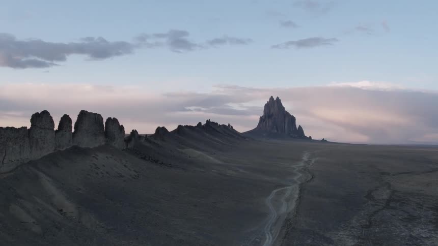 Dawn is breaking over a desert landscape with rock formations