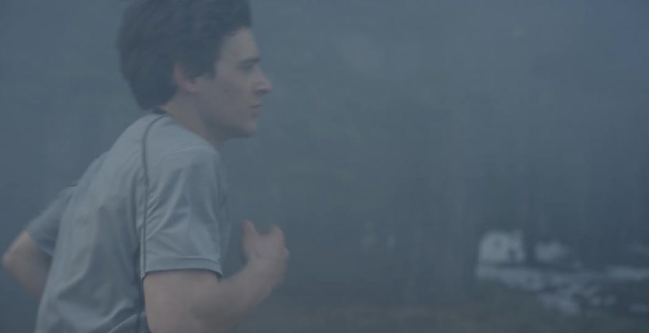 Man runs in foggy wooded area