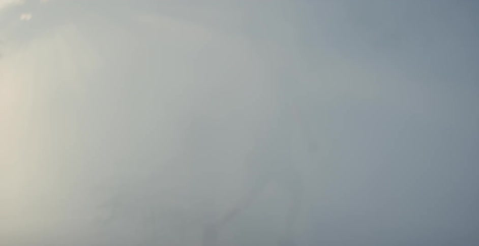A man runs through a smoky forest