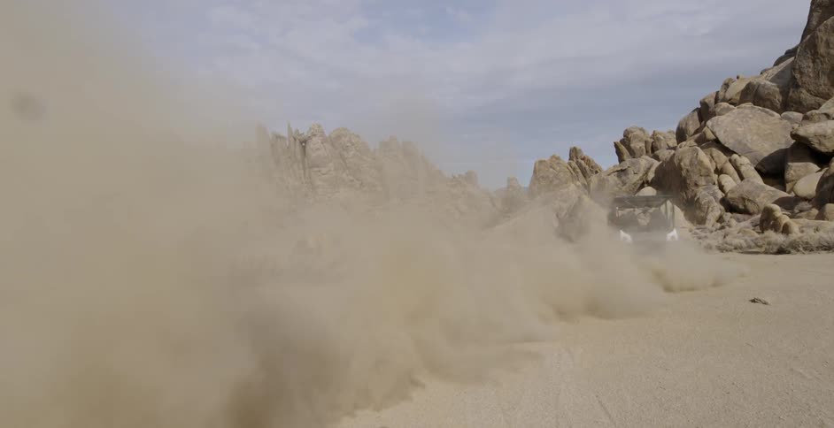 People are driving quad atvs in a desert during the day
