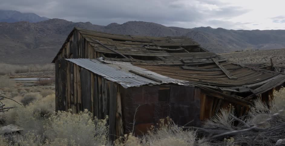 An abandoned shack sits in the desert