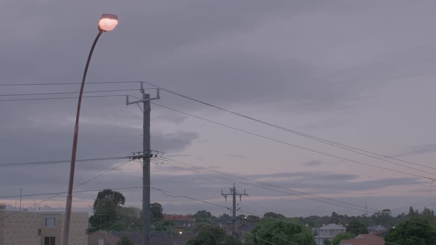 View of some power poles over a town on a cloudy day