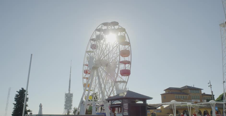 The sun shines through a still ferris wheel