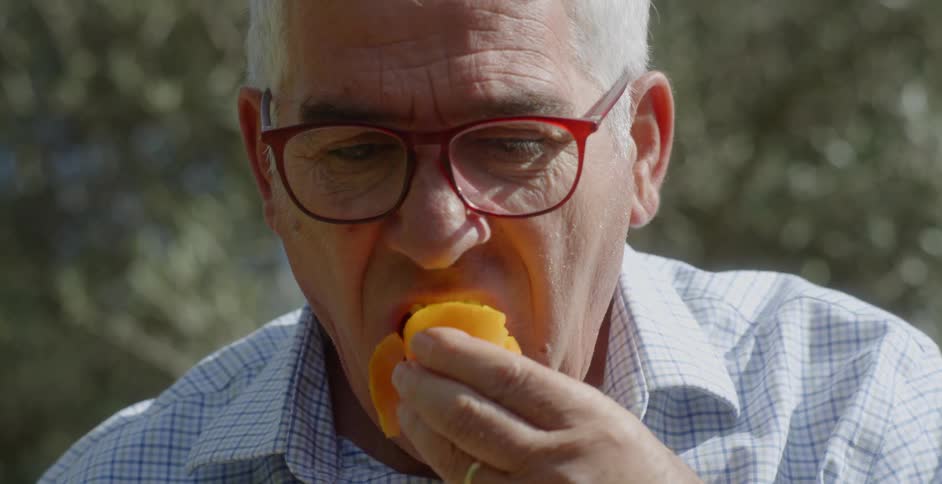 A man eats a piece of fruit