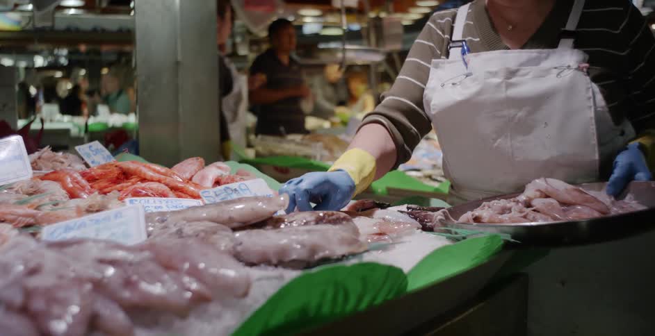 A woman sorts through seafood