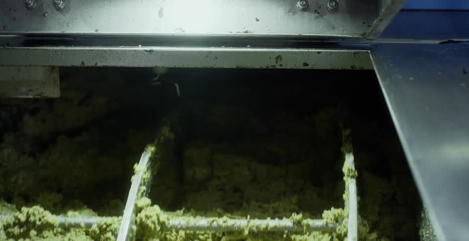 Wheel spins and mixes up green mushy material