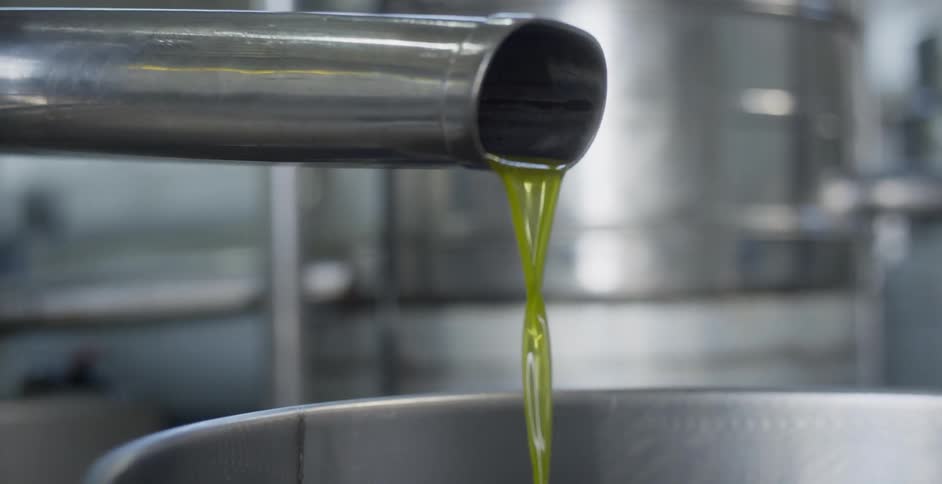 The machine is pouring yellow liquid into a container