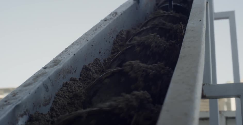 Blades rotate soil in a chute
