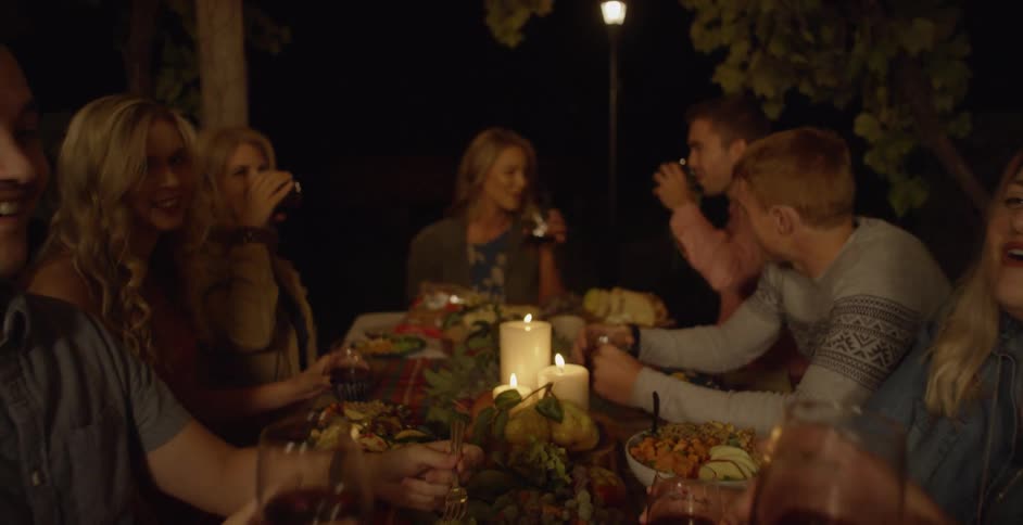 People are sitting around a table toasting with some wine