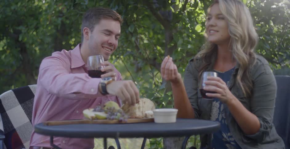 A man and woman dine outside at a table