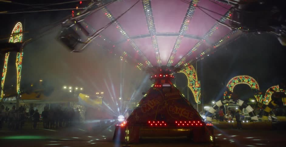People ride a carnival ride at night