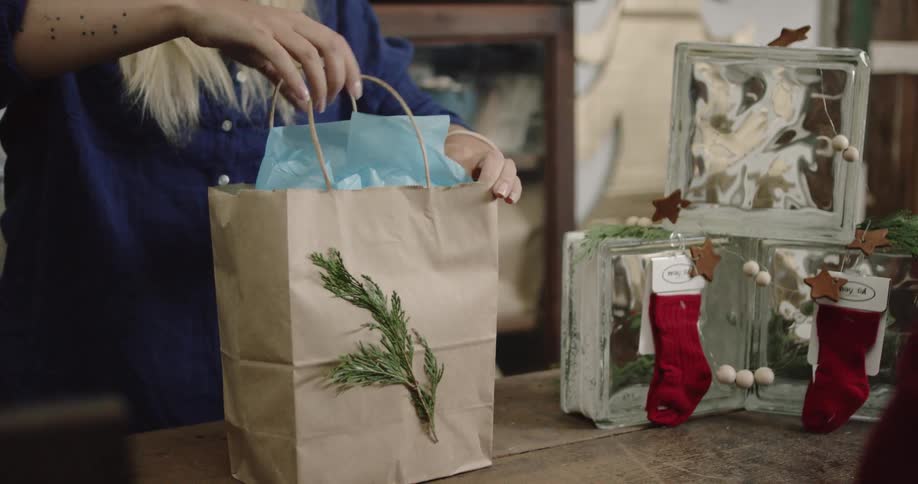 A person is packing a bag with paper