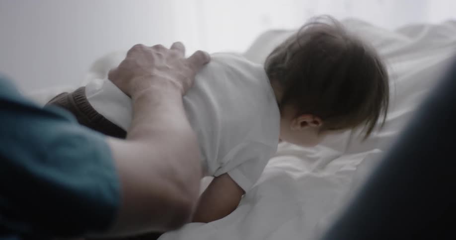 Man lies with a baby in bed