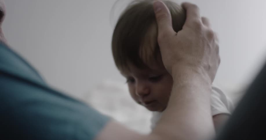 A father holds and plays with his baby