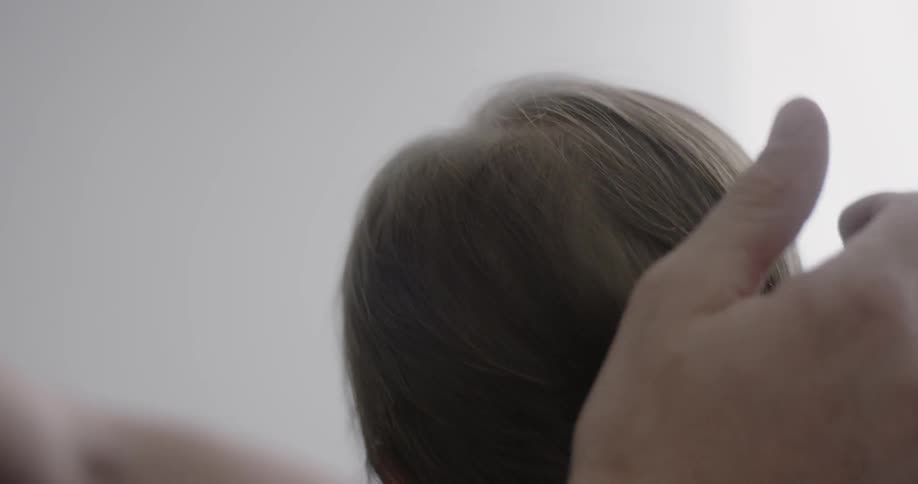 Man rubbing an infant's head while he is holding it
