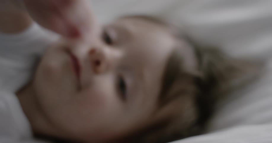 A baby rolls over waving his arms