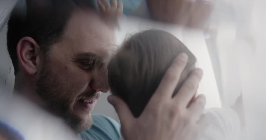A little baby and its daddy are planing under a blanket fort