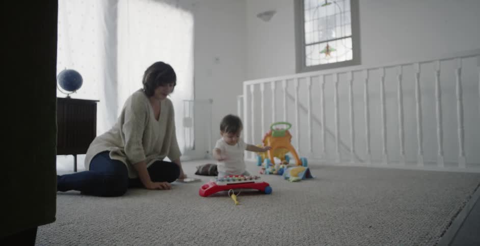 A woman and child sit by the steps together playing with toys