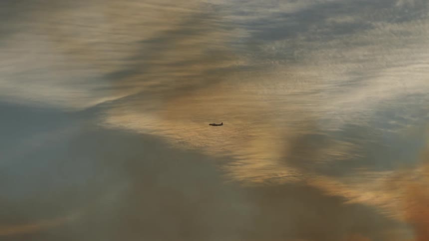 An airplanes flies above the clouds