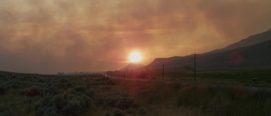 The sun sets over a rural landscape