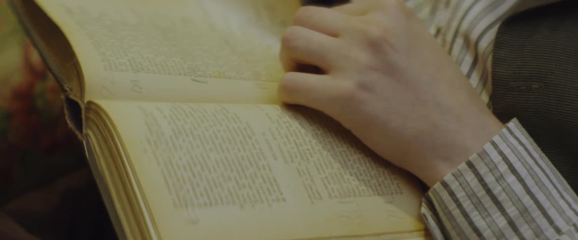 A person is reading a book and turning pages