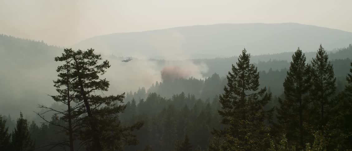 A firefighting plane drops fire retardant on a burning fire