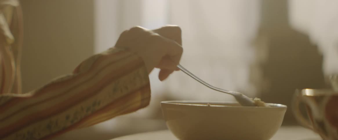 A woman stirs a bowl of food