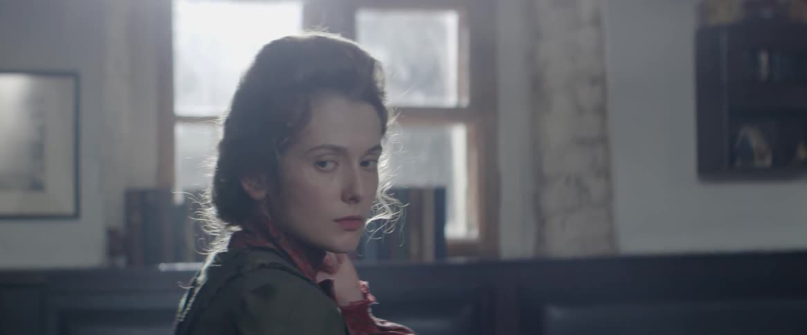 Woman sitting and looking around solemnly indoors