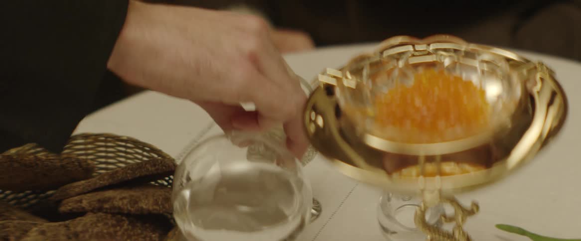 A man puts down a liquor glass. and pours shots