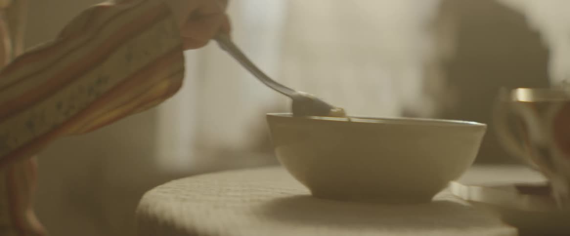 A woman stirs a bowl of food