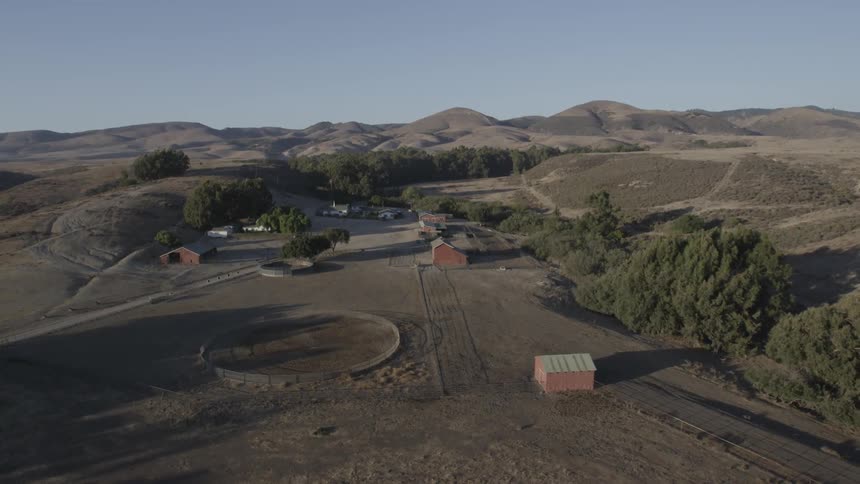 A farm sits in the middle of an open area