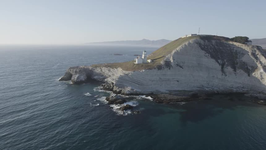 Aerial view of a lighthouse on a cliff by the water