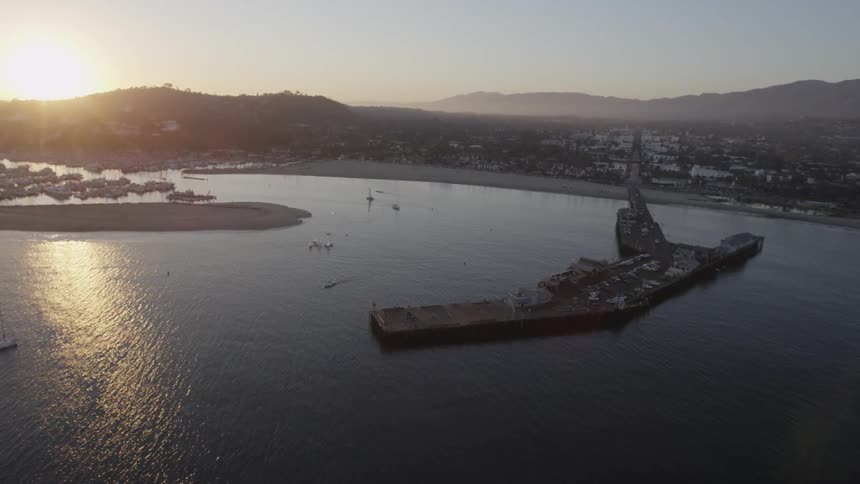 Aerial view of a lake with boats as the sun rises
