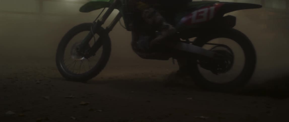 Person rides a dirt bike and stirs up the dirt