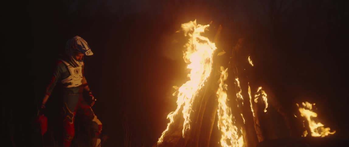 A man pours fuel on a bonfire