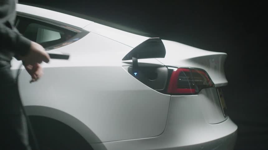 Man removes plug from electric car