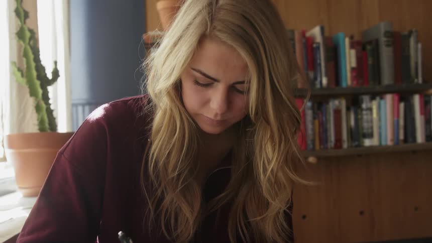 A woman writes in a notebook